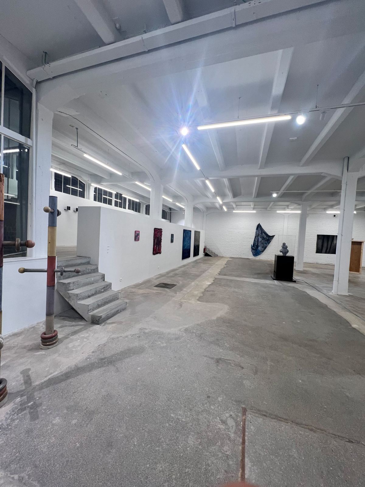 Grote hal, tentoonstellingswand en betontrap